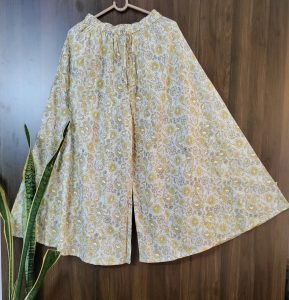 Mustard floral hand-screen printed flared cotton palazzo pants on a hanger — Palazzos