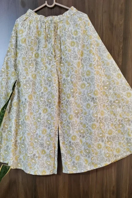 Mustard floral hand-screen printed flared cotton palazzo pants on a hanger — Palazzos
