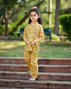 Little girl wearing a yellow floral hand-screen printed cotton night suit — Kids Night Wear
